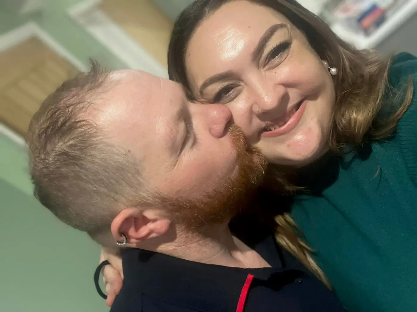 Drew kissing Raychel on the cheek while she smiles at the camera